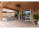 Outdoor patio with seating, a ceiling fan, and a view of the community pool through the doors at 37161 W Giallo Ln, Maricopa, AZ 85138