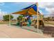 A brightly colored community playground is partially shaded for comfort at 37161 W Giallo Ln, Maricopa, AZ 85138