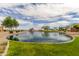 Community pond with lush green spaces at 37161 W Giallo Ln, Maricopa, AZ 85138