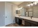 Bathroom with a double sink vanity, dark cabinets, and a view of the shower at 39960 W Bunker Dr, Maricopa, AZ 85138