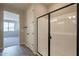 Bright bathroom featuring a black-framed glass shower and neutral walls at 39960 W Bunker Dr, Maricopa, AZ 85138