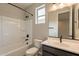 Bathroom with a shower-tub combo, dark hardware, and a window for natural light at 39960 W Bunker Dr, Maricopa, AZ 85138