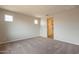 Sunlit bedroom with light walls, neutral carpet, and a view to the ensuite bathroom at 39960 W Bunker Dr, Maricopa, AZ 85138