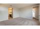 Bright bedroom featuring neutral carpet, light-colored walls, and ensuite bathroom access at 39960 W Bunker Dr, Maricopa, AZ 85138