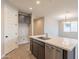 Open kitchen island with stainless steel dishwasher, pendant lights, and modern finishes at 39960 W Bunker Dr, Maricopa, AZ 85138