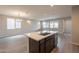 Spacious kitchen island with a sink and stainless steel dishwasher in a bright and airy room at 39960 W Bunker Dr, Maricopa, AZ 85138