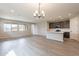 Open-concept living area with wood floors, recessed lighting, and a modern chandelier at 39960 W Bunker Dr, Maricopa, AZ 85138