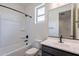 Clean bathroom with a white tub and shower combo, vanity with a gray cabinet, and a large mirror at 40025 W Bunker Dr, Maricopa, AZ 85138