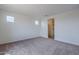 A bright bedroom with neutral carpet has two windows and a doorway at 40025 W Bunker Dr, Maricopa, AZ 85138