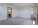A roomy bedroom has neutral carpet, two doorways, and a small window at 40025 W Bunker Dr, Maricopa, AZ 85138