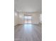 Spacious living room with sliding glass doors that lead to the backyard and light gray hardwood flooring at 40025 W Bunker Dr, Maricopa, AZ 85138