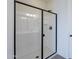 Modern glass shower featuring a black trim, white tile surround, and a door enclosure at 40025 W Bunker Dr, Maricopa, AZ 85138