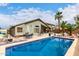 Beautiful backyard featuring a refreshing private pool, mature palm trees, and an outdoor dining area at 42491 W Chisholm Dr, Maricopa, AZ 85138