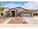 Charming single-story home featuring a well-manicured yard, a two-car garage and neutral stucco at 42491 W Chisholm Dr, Maricopa, AZ 85138