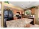 This kitchen features wood cabinets, a black refrigerator, and an island at 42491 W Chisholm Dr, Maricopa, AZ 85138