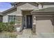 A well-maintained front entryway with stacked stone accents, a decorative front door, and a concrete path at 43650 W Snow Dr, Maricopa, AZ 85138