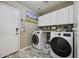 Well-equipped laundry room with modern appliances and storage cabinets for convenience at 43650 W Snow Dr, Maricopa, AZ 85138