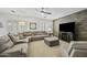 Comfortable living room featuring a stone accent wall, plush seating, and ample natural light at 43650 W Snow Dr, Maricopa, AZ 85138