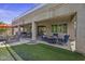 Outdoor living space with seating, a fire pit, manicured lawn, and easy access to the pool at 43650 W Snow Dr, Maricopa, AZ 85138