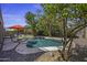 Sparkling private pool surrounded by tropical landscaping, a patio umbrella, and stylish seating at 43650 W Snow Dr, Maricopa, AZ 85138