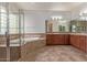 Bright bathroom features a tiled floor, dual vanity sinks, and a luxurious soaking tub and glass shower at 4522 S Wildflower Pl, Chandler, AZ 85248