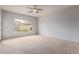 Bright bedroom with neutral carpet, ceiling fan, and large window with outdoor views at 4522 S Wildflower Pl, Chandler, AZ 85248