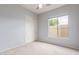 Carpeted bedroom features a window, ceiling fan, closet with sliding doors, and light-colored walls at 4522 S Wildflower Pl, Chandler, AZ 85248