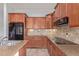 Modern kitchen with granite countertops, dark appliances, and tile backsplash at 4522 S Wildflower Pl, Chandler, AZ 85248