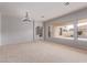 Spacious living room with plush carpet, views of the backyard, and stone fireplace feature at 4522 S Wildflower Pl, Chandler, AZ 85248