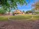 Expansive backyard featuring a lush lawn, mature trees, and an outdoor living space at 4582 S Wildflower Pl, Chandler, AZ 85248