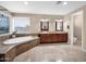 Bright primary bathroom with a soaking tub, double vanity, and separate toilet area, all with tile flooring at 4582 S Wildflower Pl, Chandler, AZ 85248