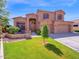 Two-story home with three car garage, seating area, terracotta roof, and manicured lawn at 4582 S Wildflower Pl, Chandler, AZ 85248