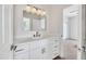 Bright bathroom featuring a white vanity with a quartz countertop and a modern, minimalist mirror with globe lights at 5222 W El Cortez Trl, Phoenix, AZ 85083