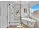 Bright bathroom features a glass shower, freestanding tub, and a large window for natural light at 5222 W El Cortez Trl, Phoenix, AZ 85083