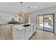 Kitchen island featuring a sink, dishwasher, and view through sliding glass doors to backyard at 5222 W El Cortez Trl, Phoenix, AZ 85083