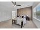 Relaxing main bedroom with a panel wall, seating bench, and entry to a main bathroom at 5222 W El Cortez Trl, Phoenix, AZ 85083