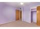 Carpeted bedroom features purple walls, a ceiling fan, electrical outlets and two wood doors at 5445 E Dallas St, Mesa, AZ 85205