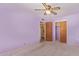 Purple bedroom with carpeted floors, two closets and a ceiling fan at 5445 E Dallas St, Mesa, AZ 85205