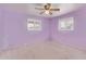 Bedroom featuring light purple walls, carpeted floors, two windows and a ceiling fan at 5445 E Dallas St, Mesa, AZ 85205