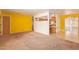 Spacious living room with neutral carpet, yellow walls, view to kitchen, and sliding glass doors at 5445 E Dallas St, Mesa, AZ 85205