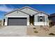 Charming single-story home with gray exterior, well-manicured landscaping, and a two-car garage at 582 W Freedom St, Florence, AZ 85132