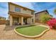 Beautiful backyard with a covered patio, plush green area, and low-maintenance desert landscaping at 6626 W Laurel Ave, Glendale, AZ 85304