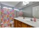 Bathroom featuring a single sink vanity, a mirror, and a shower with colorful floral curtain at 6626 W Laurel Ave, Glendale, AZ 85304
