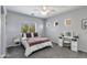 Bright bedroom with a window, lighted vanity, ceiling fan, and light gray carpet at 6626 W Laurel Ave, Glendale, AZ 85304