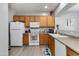 Bright kitchen with oak cabinets, white appliances, and light countertops at 6626 W Laurel Ave, Glendale, AZ 85304