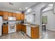 Modern kitchen with oak cabinets, stainless sink and arched access to dining area at 6626 W Laurel Ave, Glendale, AZ 85304