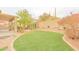 Expansive backyard featuring an artificial lawn, a built-in sitting area, and mature desert landscaping at 6778 W Lariat Ln, Peoria, AZ 85383