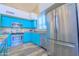 Bright kitchen showcasing stainless steel appliances, granite countertops, and blue cabinets at 6778 W Lariat Ln, Peoria, AZ 85383
