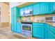 Well-lit kitchen featuring stainless steel appliances, granite countertops, and stylish blue cabinets at 6778 W Lariat Ln, Peoria, AZ 85383