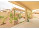 Inviting covered patio featuring a stylish pergola, a cozy seating area, and a beautiful stone accent wall at 6778 W Lariat Ln, Peoria, AZ 85383